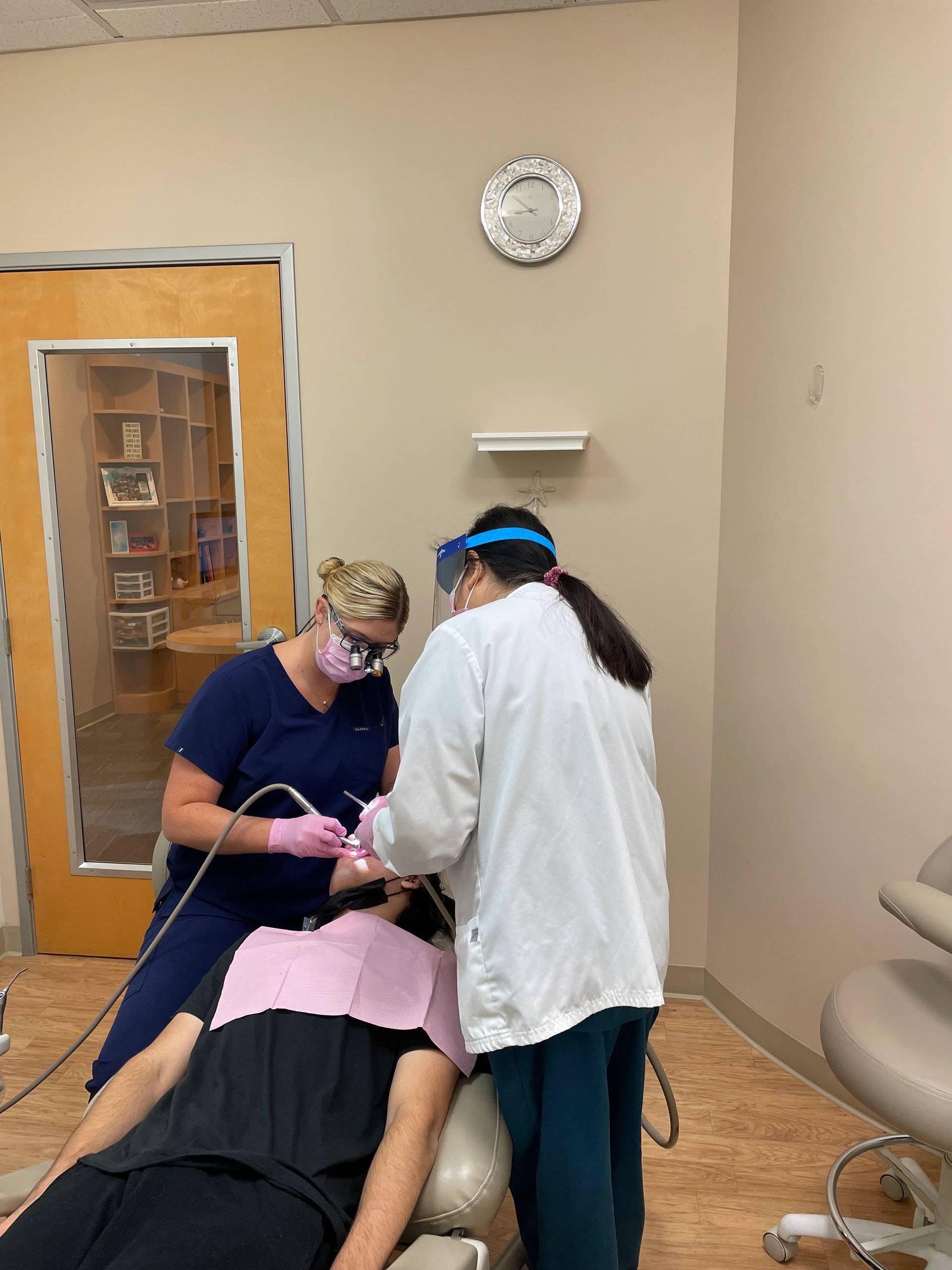 Dental professionals performing patient examination