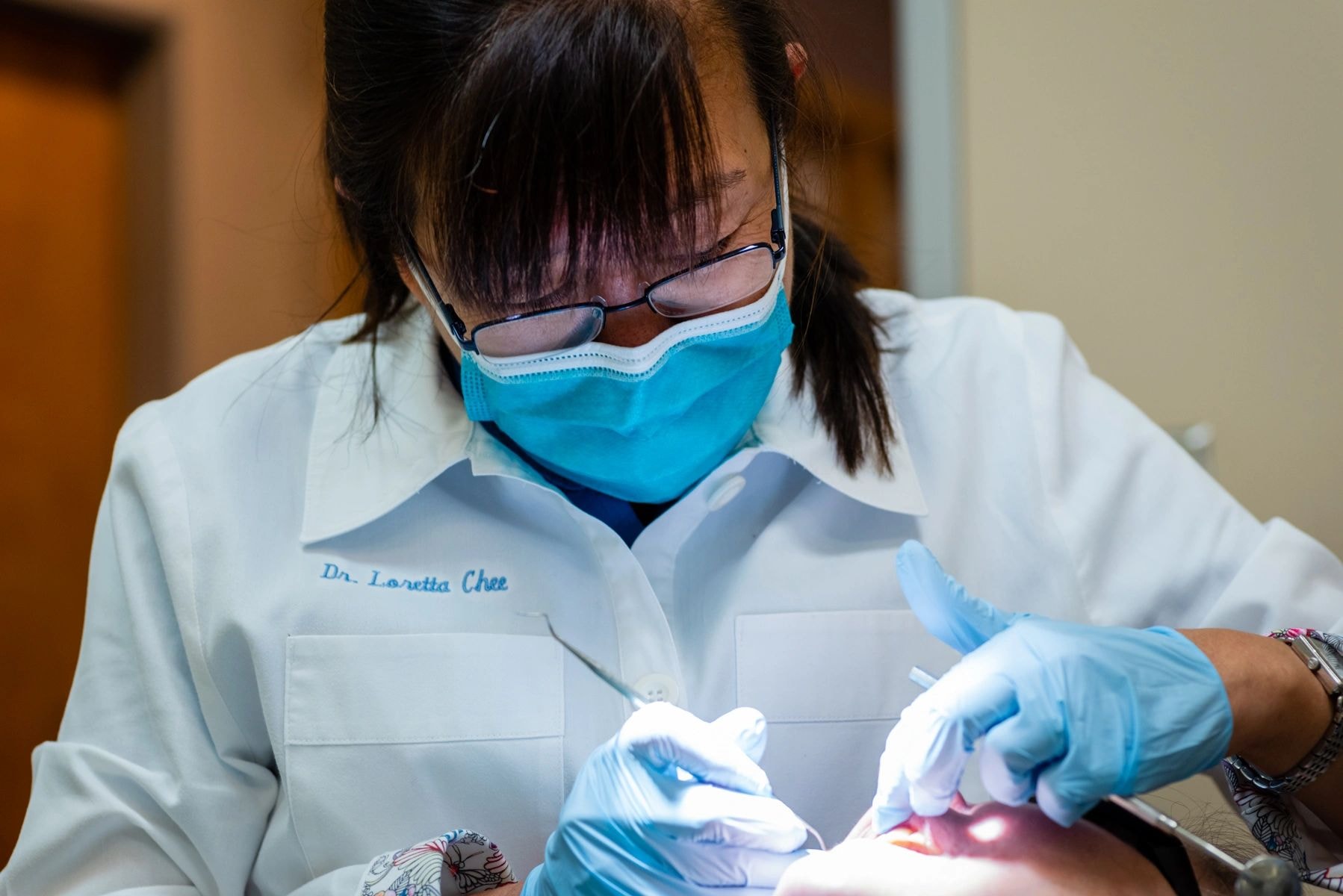 Dentist examining patient teeth with tools
