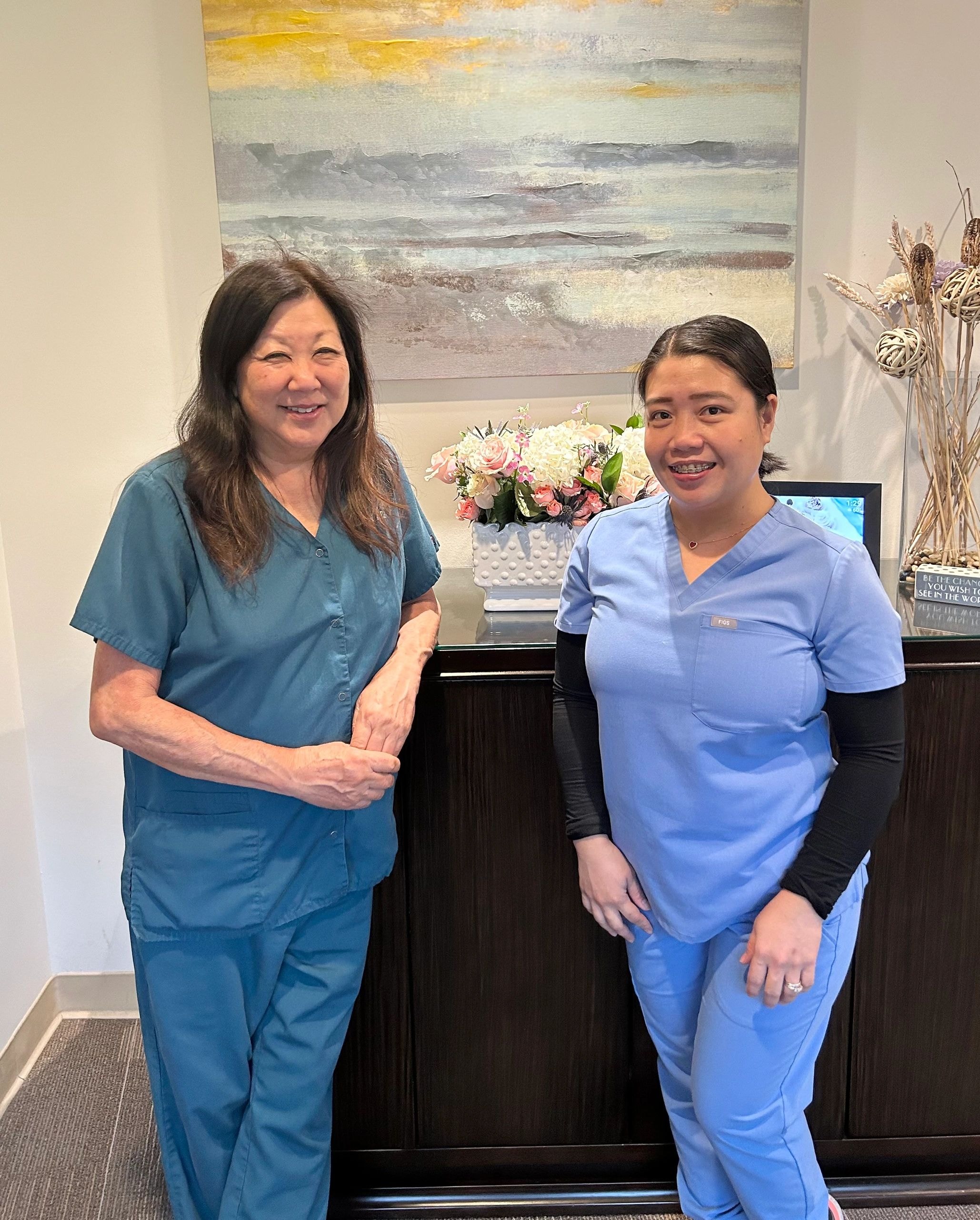 Two healthcare workers smiling at medical office