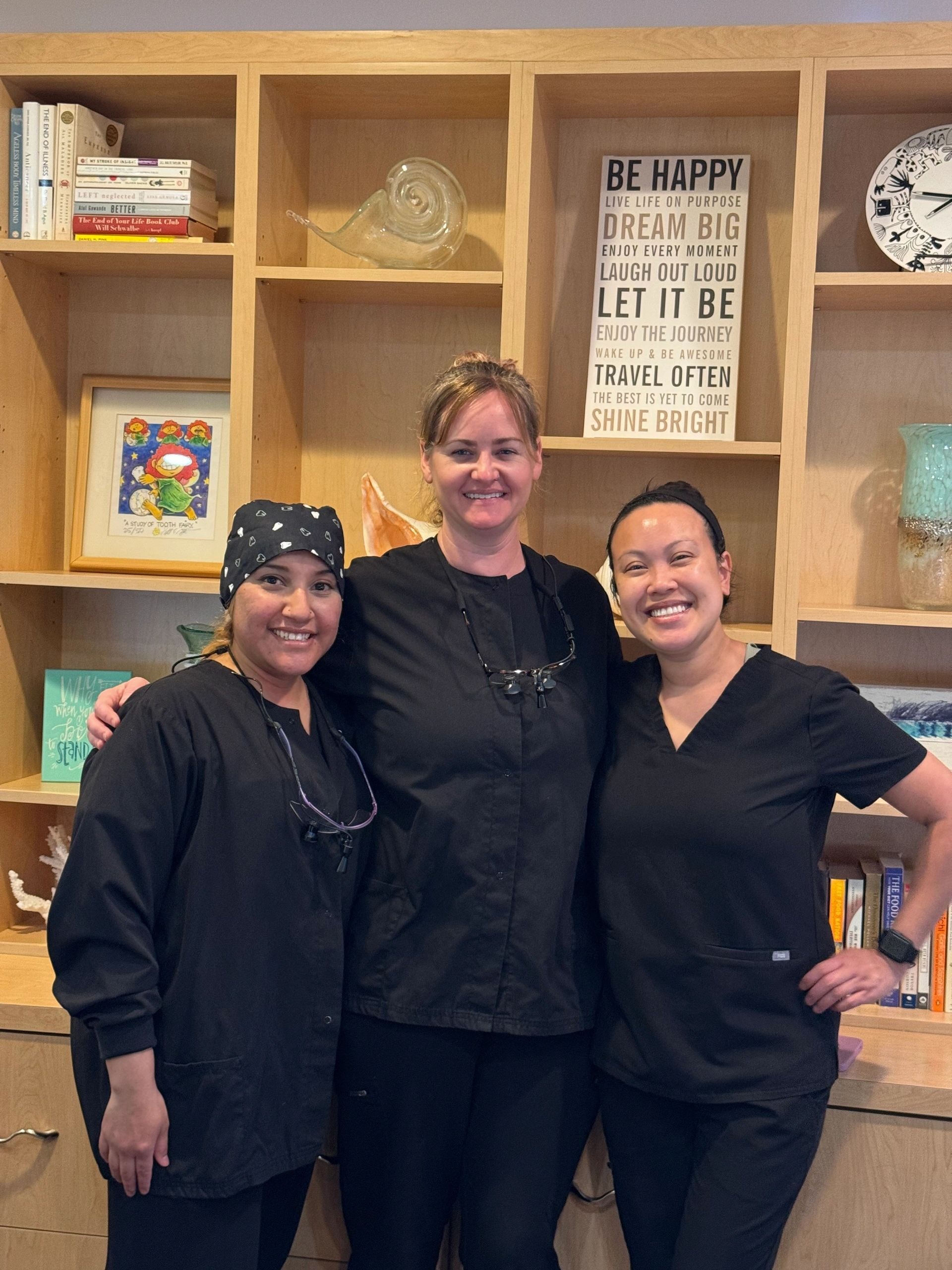 Three healthcare workers smiling together